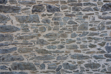 Stone wall made of antique old stone masonry close up. Wallpaper concept