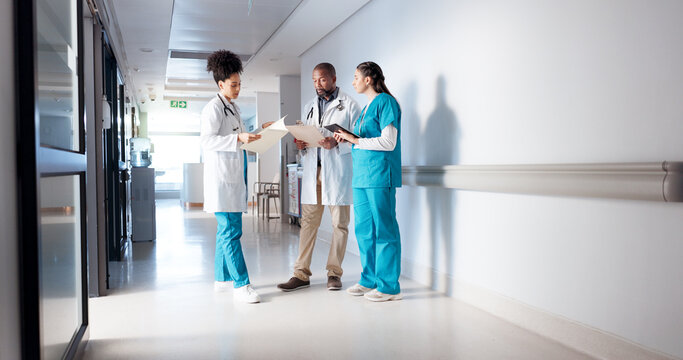 Hospital, meeting and doctors in hallway with notes for consulting, patient results and planning. Healthcare, collaboration and man and women with medical service, diagnosis and help in clinic - Powered by Adobe