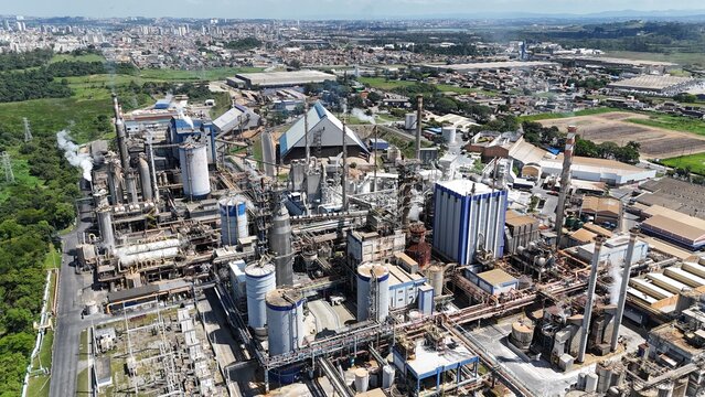 Drone sobrevoa chamin&eacute;s de uma ind&uacute;stria de papel com denso vapor sendo liberado. Destaque para os processos t&eacute;rmicos da planta industrial