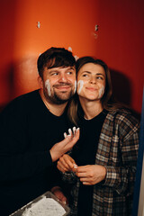 A couple with painted faces continues the cheerful renovation process, showing how they enjoy the work.