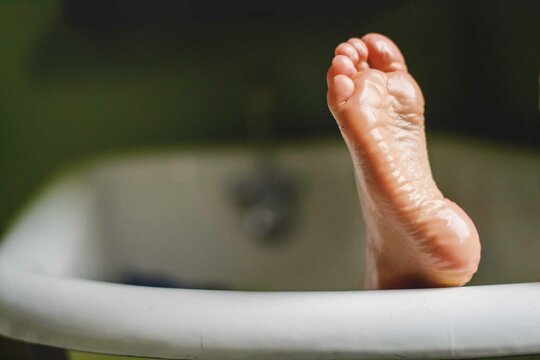 Close-up of a Boy's wet foot sticking out of a bathtub
