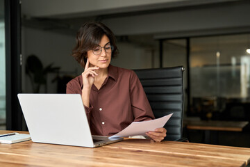 Businesswoman ceo executive or legal expert using laptop computer at work. Busy serious young...