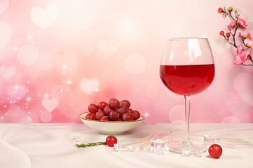 Modern still life with glass of red wine, orange slices, ice and grapes on elegant background with sakura flowers, minimalist bar and summer party concept, advertising banner and menu for cafe.