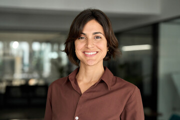 Young happy smiling Hispanic businesswoman leader, female company worker or corporate manager,...