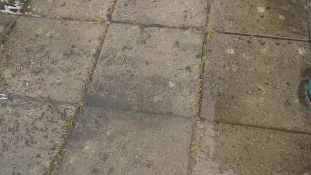 a round high-pressure washer cleaning old dirty concrete slabs