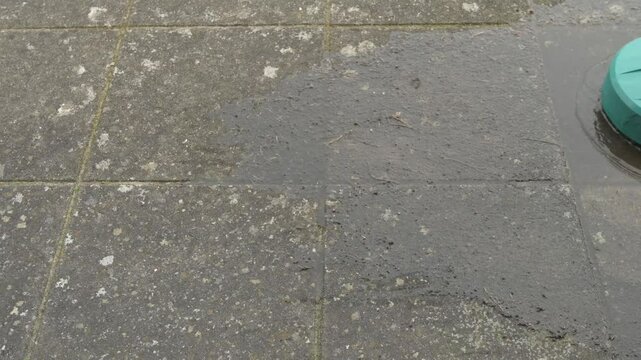 a round high-pressure washer cleaning old dirty concrete slabs