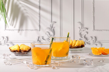 Cocktail or punch of tequila, rum and vodka with pineapple slices, orange, ice and rosemary. Summer...