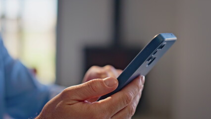 Guy finger swiping cellphone at modern office closeup. Man holding telephone