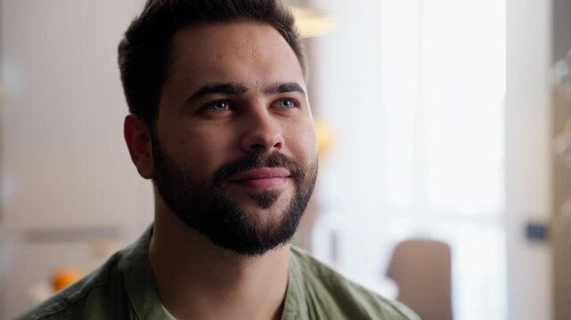 Relaxed dreamy inspired bearded adult Caucasian smiling happy business man male guy homeowner businessman looking distance thinking daydreaming nostalgia portrait at home indoors living room apartment
