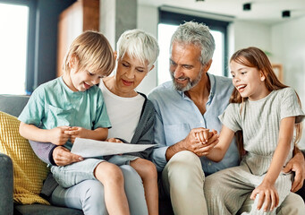grandchild family child grandparent grandfather happy together grandmother girl senior boy read...