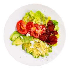 Delicious fresh lettuce salad and tomatoes served with chorizo and avocado on plate. Isolated over white background
