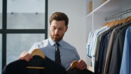 Focused director choosing blazer having doubt between two at apartment closeup