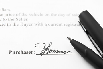 Signature and pen on paperwork, closeup view