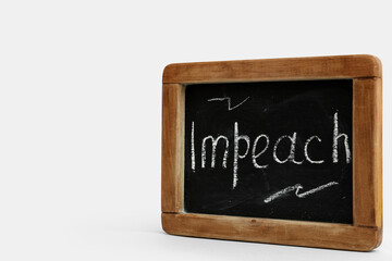 Obraz premium Chalkboard with word IMPEACH on white background