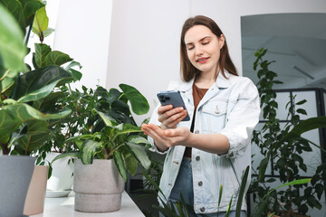 Woman using houseplant recognition application on smartphone indoors