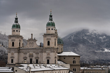 Cloudy Salzburg rooftop view, historical architecture, mountains, Austria winter.