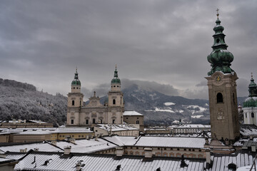 Cloudy Salzburg rooftop view, historical architecture, mountains, Austria winter.