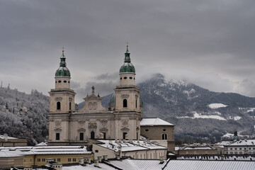 Cloudy Salzburg rooftop view, historical architecture, mountains, Austria winter.