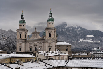 Cloudy Salzburg rooftop view, historical architecture, mountains, Austria winter.