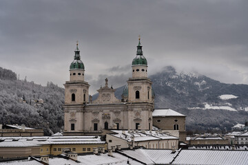 Cloudy Salzburg rooftop view, historical architecture, mountains, Austria winter.