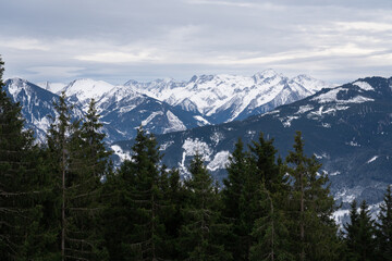 Cloudy January alpine landscape with mountains, trees, Austria.