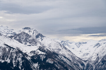 Cloudy January alpine landscape with mountains, trees, Austria.