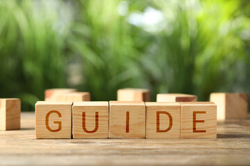 Word Guide made of wooden cubes on table outdoors