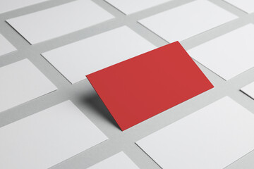 Difference, uniqueness, individuality. Red business card among white ones on grey background
