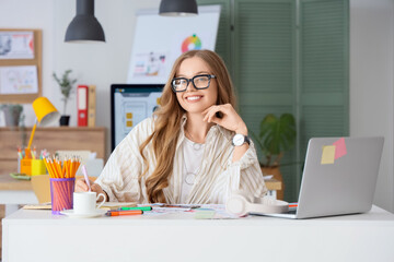 Female web designer working at table in office