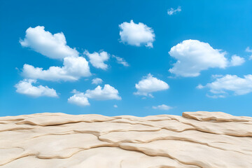 Fototapeta premium Textured beige landscape under a vibrant blue sky with fluffy white clouds
