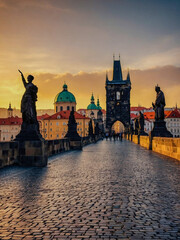 Charles Bridge over the Vltava River in Prague at sunset.