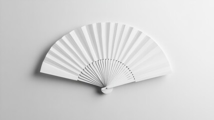 A minimalist white fan elegantly spread out against a soft gray backdrop, showcasing its sleek design and texture