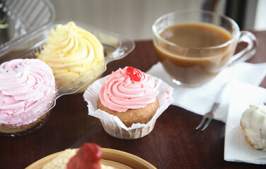 Tasty cupcakes with whipped cream, berries and coffee