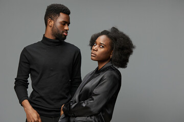Stylish couple portraying modern elegance with deep emotions in a minimalistic studio setting, featuring dark clothing and soft colors, perfect for diverse themes