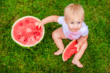 Little one enjoying summer treat with big bite of watermelon