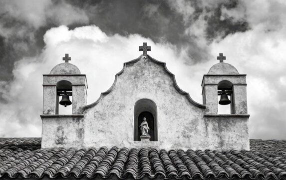 Black and white photograph of the top roof of Mission San Luis Obispo de Tolosa, with three bells on each side of an arched window at its center Generative AI