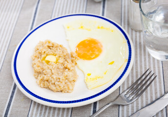 Breakfast with scrambled eggs and oatmeal with butter