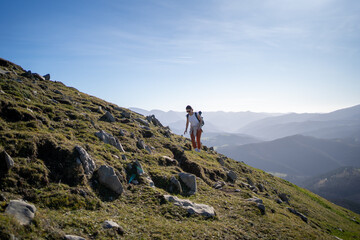 Fototapeta premium A hiker enjoys the experience on a scenic mountain trail surrounded by a clear blue sky