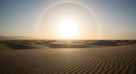 Naklejka premium Sun halo over desert with golden sunlight