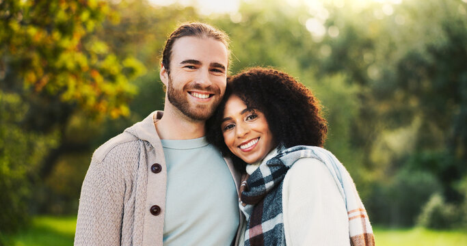 Portrait, happy and couple hug in park for support, love and affection outdoors in morning. Interracial, nature and man and woman embrace for bonding, relationship and romance together in garden