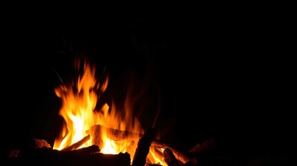 Fototapeta premium Bonfire at Night with Vibrant Orange and Red Flames Casting Warm Glow