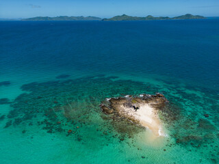 A deserted tropical island surrounded by turquoise waters.