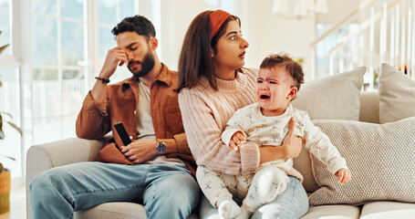 Home, man and woman with baby, crying and stress for new parents with child, lounge and noise. Family, father and annoyed by interruption from game, thinking or mother with emotional toddler in house