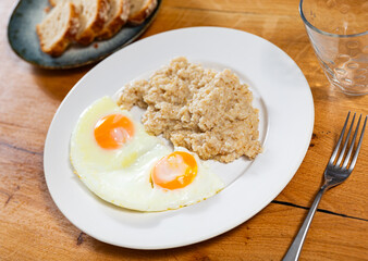 Breakfast with scrambled eggs and oatmeal with butter