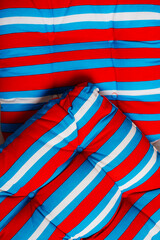 A close-up of a bright striped fabric in red and blue tones, ideal for textile design inspiration.