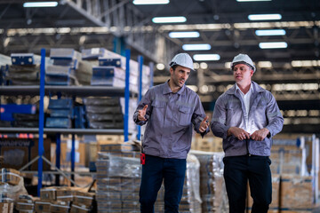 A team of engineers inspects the warehouse in a large storage warehouse. The inspection team uses...