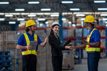 A team of engineers inspects the warehouse in a large storage warehouse. The inspection team uses...