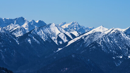 Obraz premium Majestic snow-capped mountains under a clear blue sky in winter landscape showcasing natural beauty