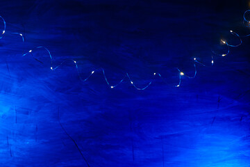 Blue Background with Fairy Lights.Christmas Shining texture. lights of garlands on a blue background.Golden lights of garlands