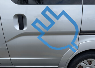 A blue symbol on the side of a silver car indicates the vehicle is an electric plug in type